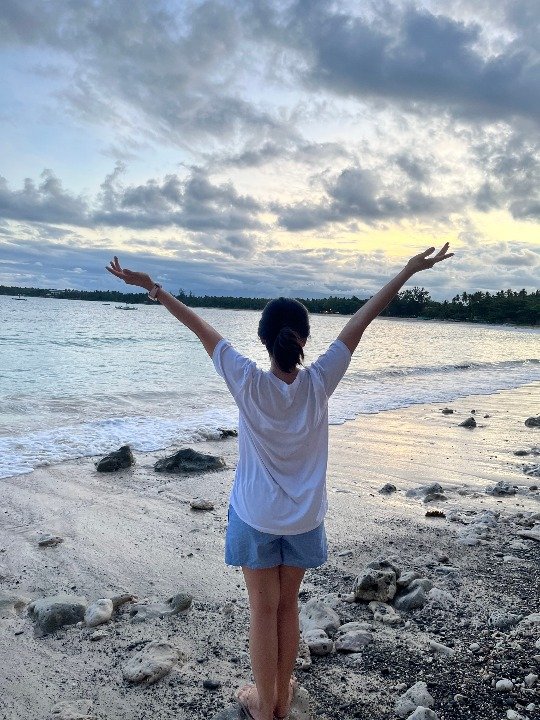 pinterest manager relaxing on a beach with arms stretched open